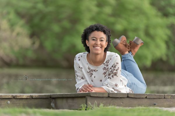 high school senior lying on stomach on boat dock