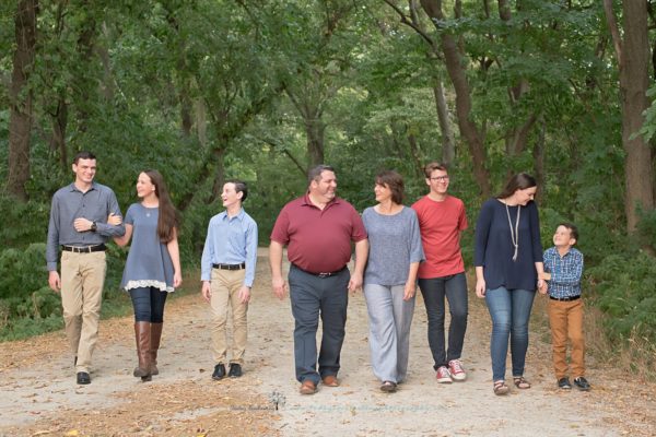 A large family walking side by side. They are looking at each other and smiling.