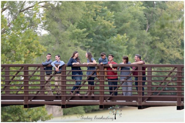 family group laughing together on an old metal bridge