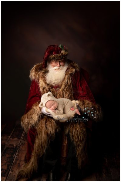 Santa holding tiny newborn baby 