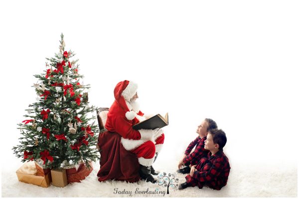 Santa reading a story to little boys with holiday decor