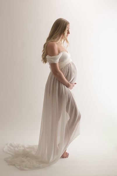 Pregnant woman wearing a white gown.