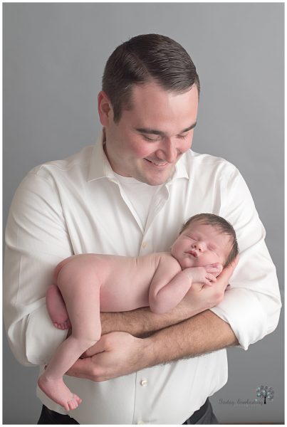 A father holding his newborn son and smiling in Morris IL